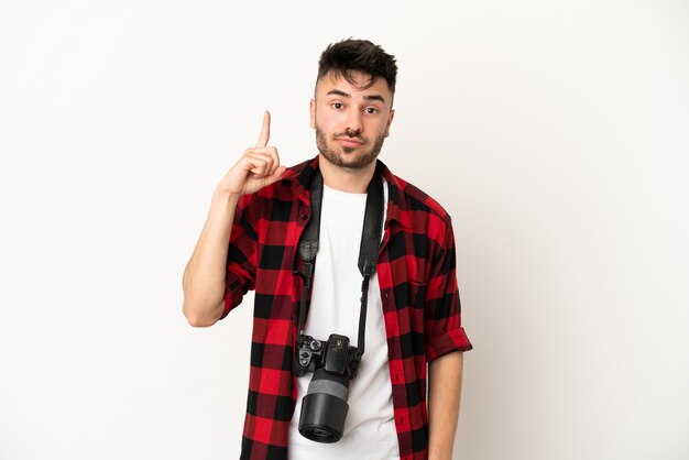 Kaukasischer Mann des jungen Fotografen lokalisiert auf weißem Hintergrund, der mit dem Zeigefinger zeigt, eine großartige Idee