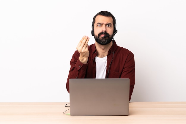 Kaukasischer Mann des Telemarketers, der mit einem Headset und mit Laptop arbeitet, die italienische Geste machen.