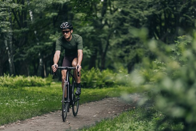 Kaukasischer Mann in Sportkleidung, der Fahrrad an der frischen Luft fährt