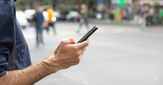 Kaukasischer Mann mit Smartphone in der Stadt