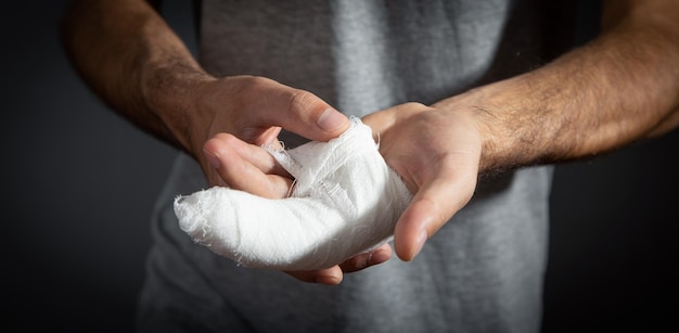 Kaukasischer Mann mit Verband in der verletzten Hand