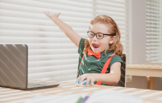 Kaukasischer Schuljunge hat Videoanruf entfernte Klasse mit Lehrer mit Laptop glückliche kleine Kinderwelle