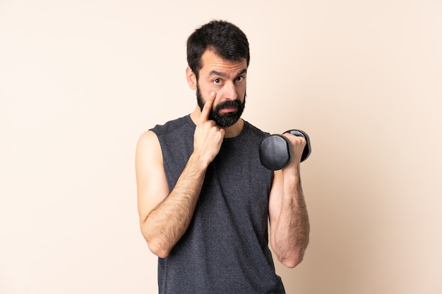 Kaukasischer Sportmann mit Bart, der Gewichtheben macht
