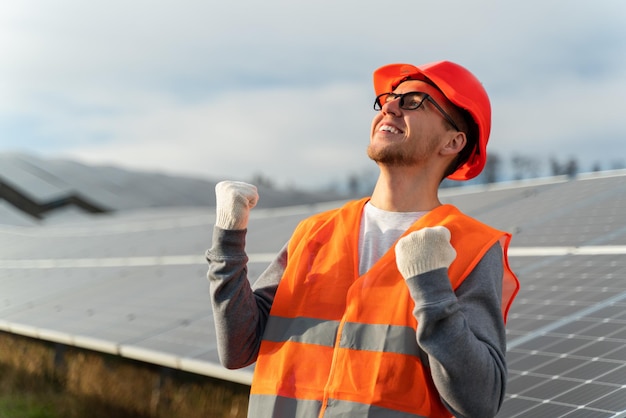 Kaukasischer Techniker mit Helm, der für eine Solarpanel-Anlagenindustrie arbeitet