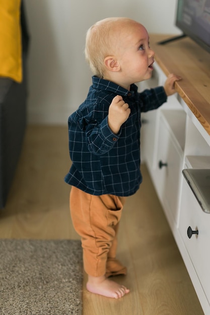 Kaukasisches Baby, Neugeborenes, das erste Schritte macht Süßes Kleinkind, Kind, Sohn, Junge, der lernt, zu Fuß im Wohnzimmer zu kriechen Kinderbetreuung und Kindheit Konzept