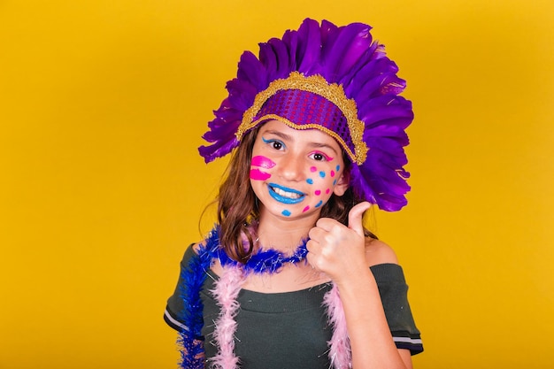 Kaukasisches brasilianisches Kind, das für den Karneval gekleidet ist. Daumen hoch, Bestätigung der Zustimmung