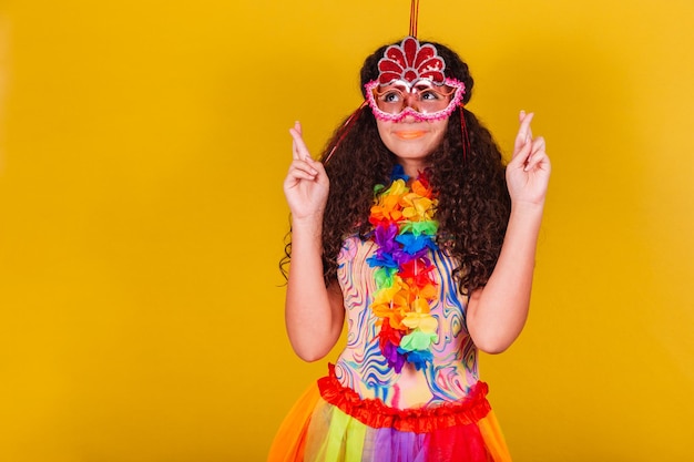 Kaukasisches brasilianisches Mädchen, gekleidet für Karneval. Daumen drücken, hoffend hoffend