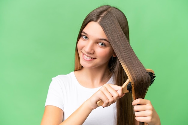 Kaukasisches Mädchen des Teenagers mit Haarkamm über lokalisiertem Hintergrund