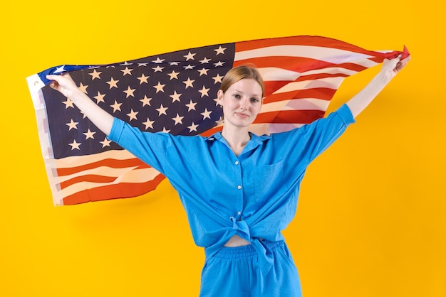 Kaukasisches Mädchen Glückliche junge Frau in blauer Kleidung mit isolierter USA-Flagge