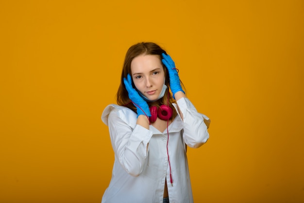 kaukasisches Mädchen in der blauen farbigen schützenden Gesichtsmaske und in den Handschuhen.