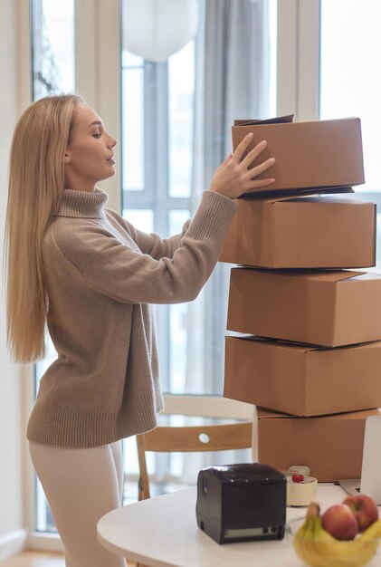 Foto kaukasisches mädchen klebt kisten für den umzug in eine neue wohnung