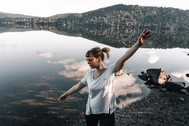 Foto kaukasisches mädchen mit gesammeltem haar sonnenbrille grau t-shirt schwarze hose ruhig und entspannt mit