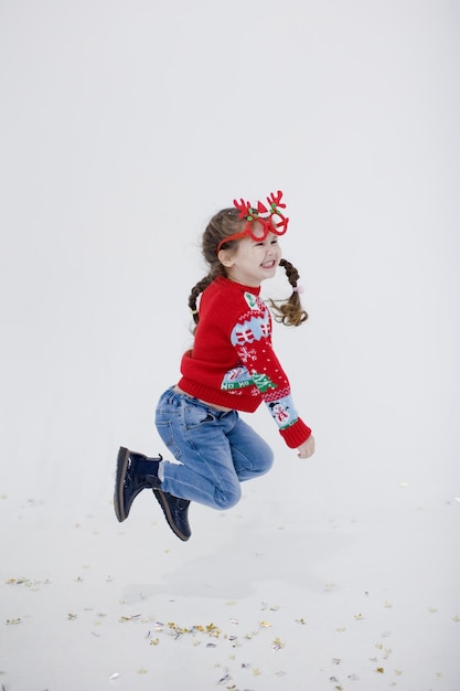 Kaukasisches Vorschulmädchen in der Weihnachtsstrickjacke