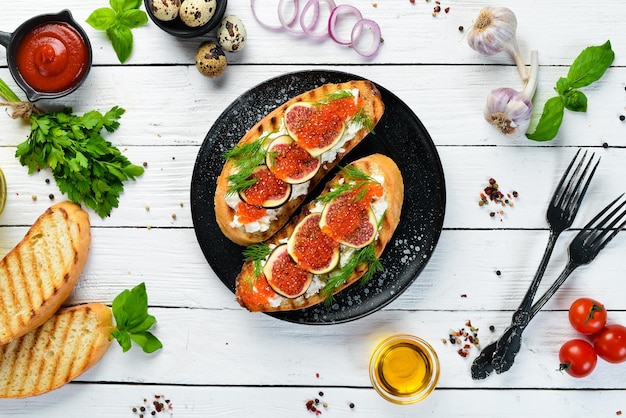 Kaviar-Sandwich mit Feta-Käse und Feigen auf einer schwarzen Platte Draufsicht Freier Kopierbereich