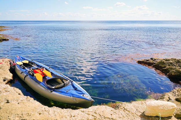 Kayak com remos na pitoresca praia de pedra.