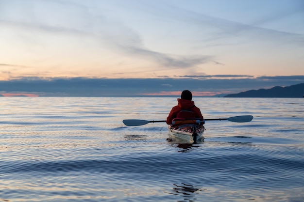 Kayak en el océano durante la puesta de sol