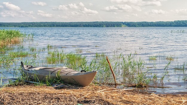 Foto kayak en la orilla arenosa del lago en un día soleado y brillante luz natural