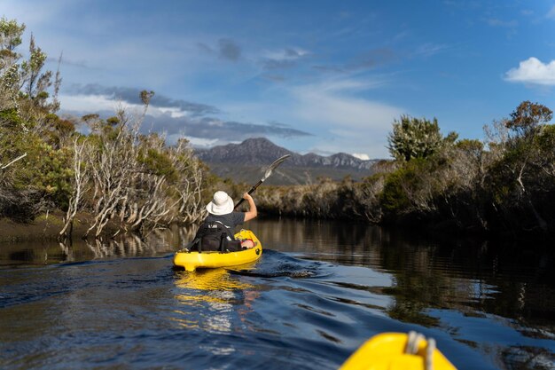 Foto kayaking um rio em uma canoa com montanhas em um deserto em um parque nacional com plantas nativas e árvores em uma floresta tropical na austrália com rios e explorar na austrália