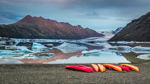 Kayaks en el lago glacial en las montañas Islandia en verano