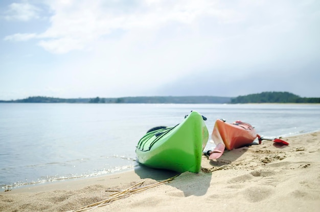 Los kayaks de mar se encuentran en la playa de arena a orillas del embalse cuando hace sol