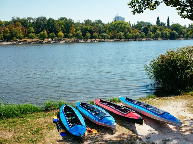 Kayaks vacíos en la orilla del río.