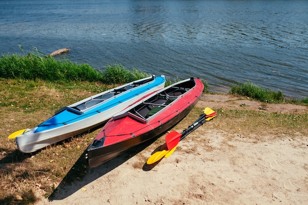 Kayaks vacíos en la orilla del río.