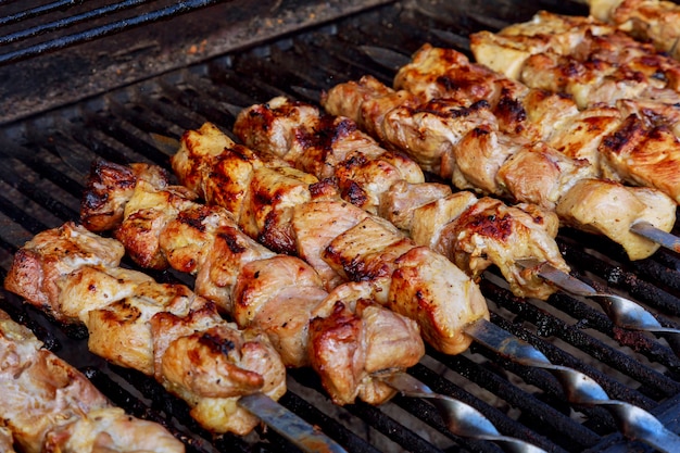 Kebab asado a la parrilla que cocina en el primer del pincho del metal. Carne asada cocinada en la barbacoa.