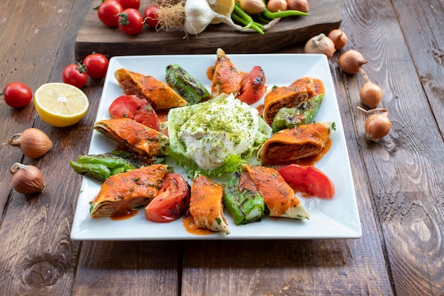 Kebab beyti turco tradicional servido en un plato con ensalada y arroz