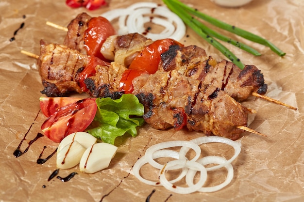 Kebab de carne de cerdo con salsas y verduras