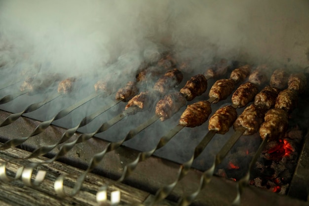 un kebab cocinando en un fumador al aire libre y fuego