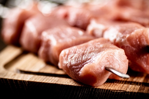 Foto kebab crudo de cerdo en una tabla para cortar