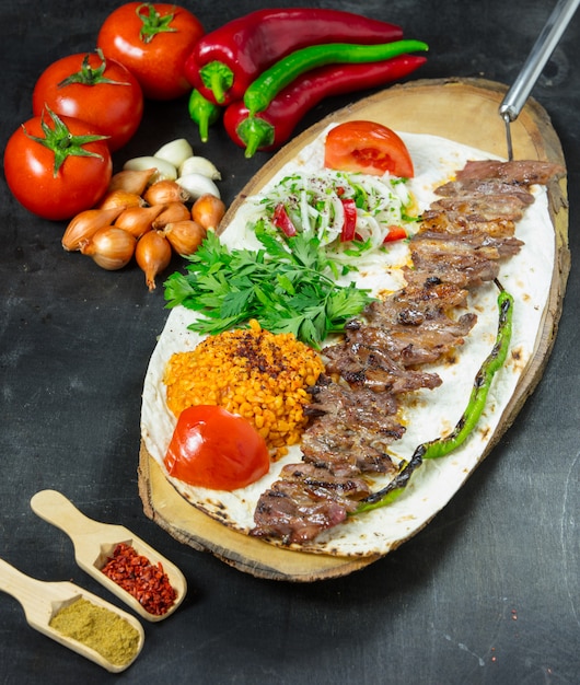 Kebab de adana turca com legumes no prato