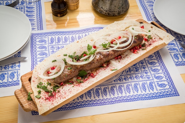 Kebab de Lula com ervas em uma superfície de madeira