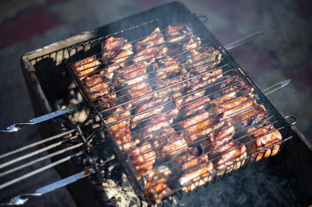 Kebab frito em uma grelha caseira com profundidade de campo rasa de fumaça