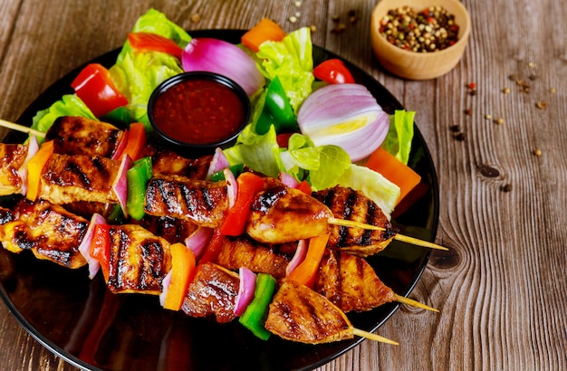 Kebab na vara de madeira com salada fresca.