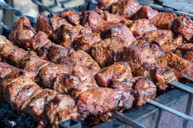 Kebab a la parrilla cocinando en brocheta de metal closeup Carne asada cocinada en barbacoa Barbacoa carne de res fresca rebanadas de chuleta Plato tradicional oriental shish kebab