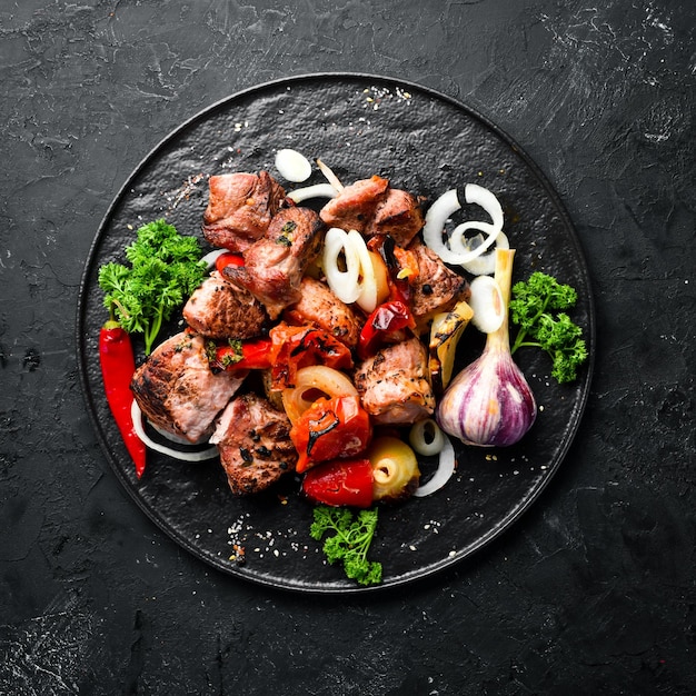 Kebab en un plato Carne al horno con cebollas y tomates Barbacoa Vista superior Espacio libre para su texto Estilo rústico