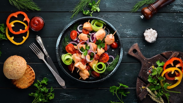 Kebab de pollo con verduras Kebab en un plato negro Vista superior Espacio de copia libre