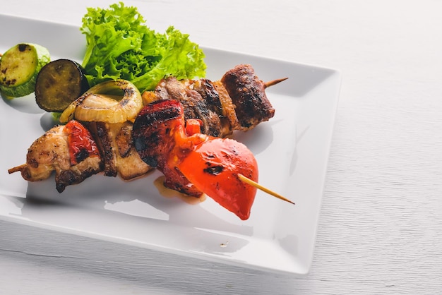 Kebab de ternera cerdo y verduras a la parrilla Sobre un fondo de madera Vista superior Espacio libre