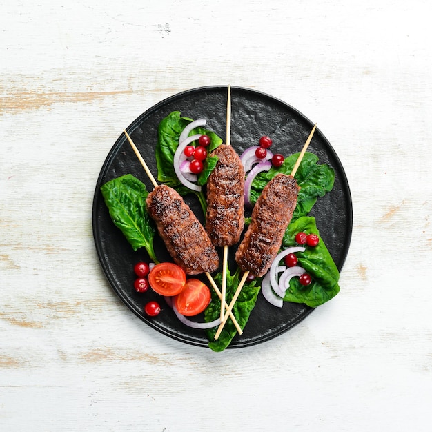 Kebab Tradicional kebab de carne árabe o mediterránea del Medio Oriente con verduras y hierbas Vista superior Espacio libre para el texto