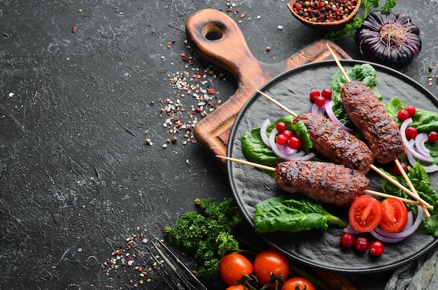 Kebab Tradicional kebab de carne árabe ou mediterrâneo do Oriente Médio com legumes e ervas Vista superior Espaço livre para o seu texto