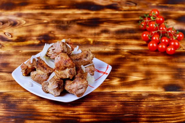 Kebabs cocidos con verduras y especias sobre tabla de madera