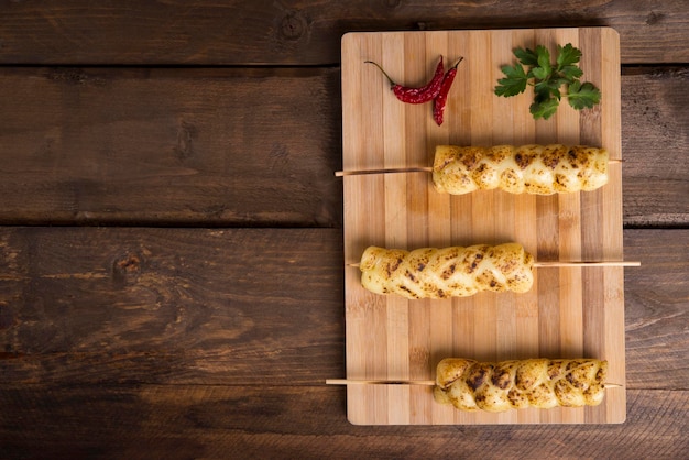 Kebabs de mussarela (espetinho), pimenta em fundo de madeira claro e escuro