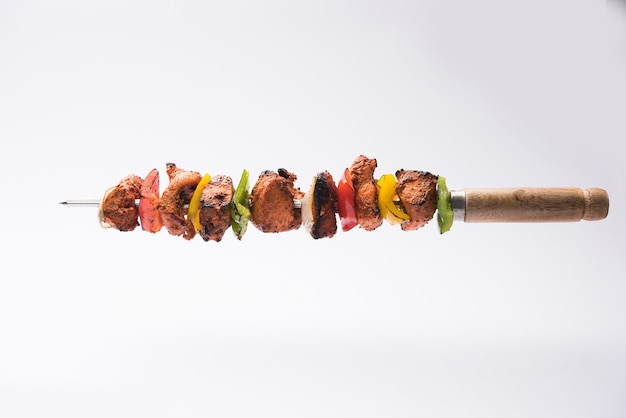 Foto kebabs tikka de frango indiano, marinado em especiarias e iogurte e assado em tandoor