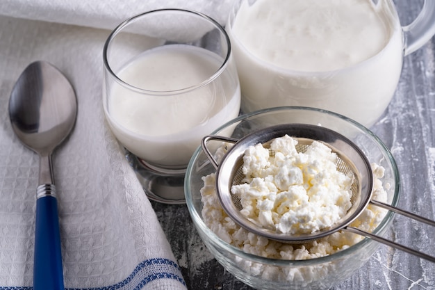 Kefir de bebida fermentada em um copo e requeijão na tigela de vidro.