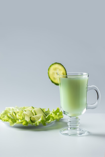 Kefir, verduras e suco de pepino, uma bebida com leite azedo. Sobre fundo branco