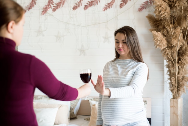 Kein Alkohol während der Schwangerschaft. Junge schwangere Frau weigert sich, Wein zu trinken.