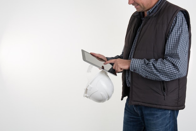 Kein Gesicht Nicht erkennbare Person. Torso-Ingenieur, Arbeiter oder Architekt, der einen weißen Kunststoffhelm in der Hand hält, Tablet isoliert auf weißem Hintergrund Leerer Kopierbereich für Beschriftungen, Objekte