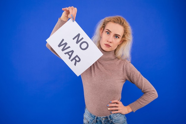 Foto kein krieg junge frau mit einem plakat auf blauem grund