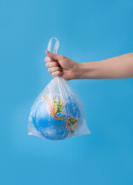 Foto kein plastikkonzept. hände halten planetenerde in plastiktüte.